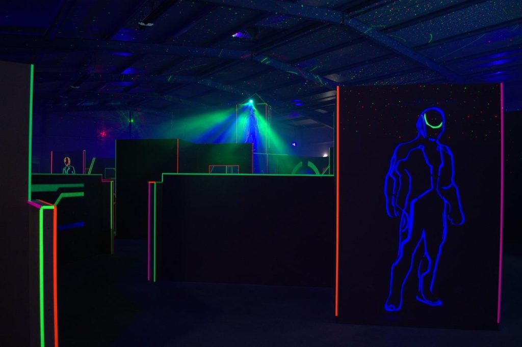 Groep spelers speelt spannend avontuur lasergamen in de openlucht met professionele uitrusting en teamstrategie