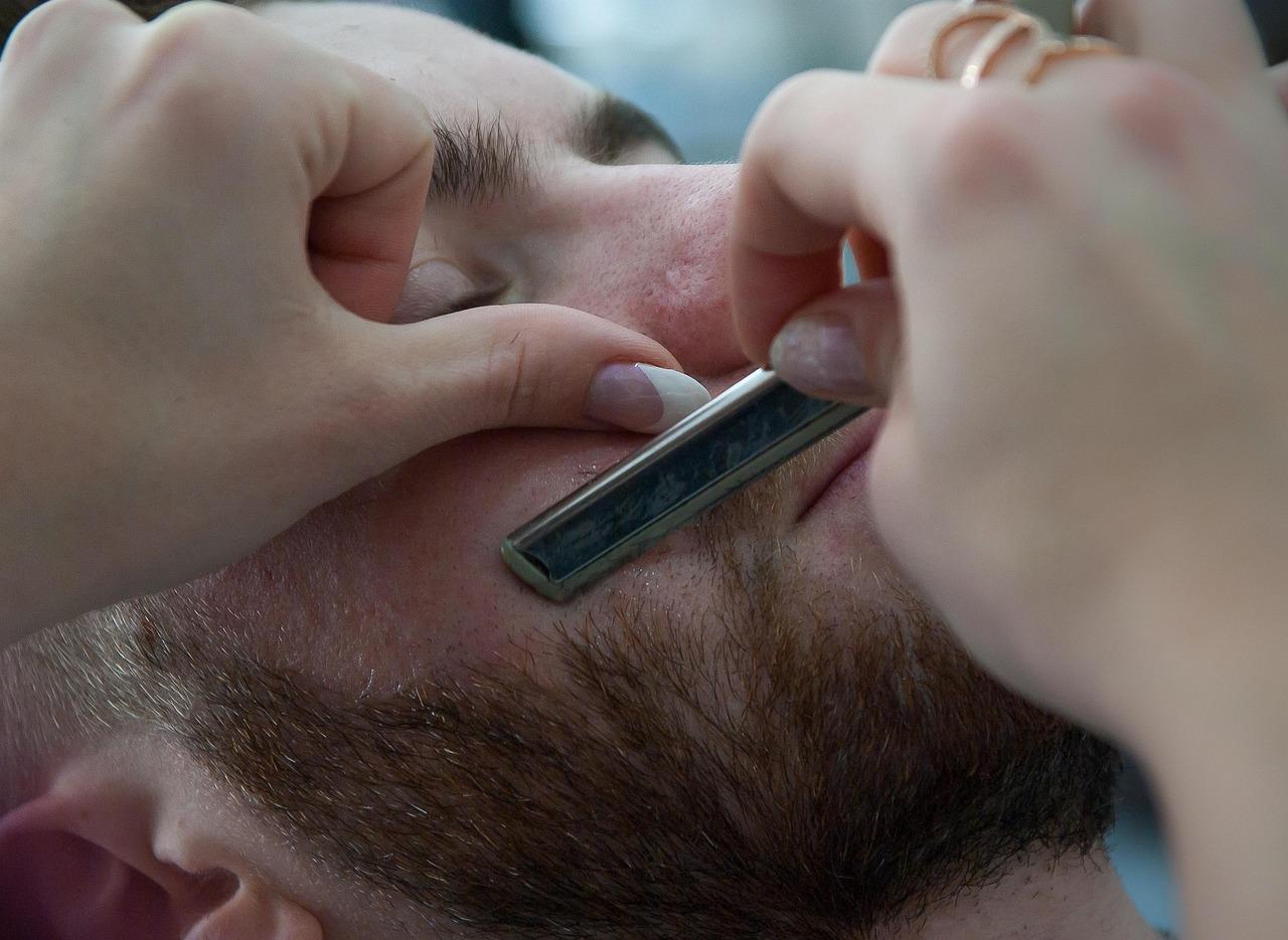Moderne barber in Amsterdam aan het werk, klassieke barbershop inrichting met vintage spiegels en karakteristieke kappersstoe