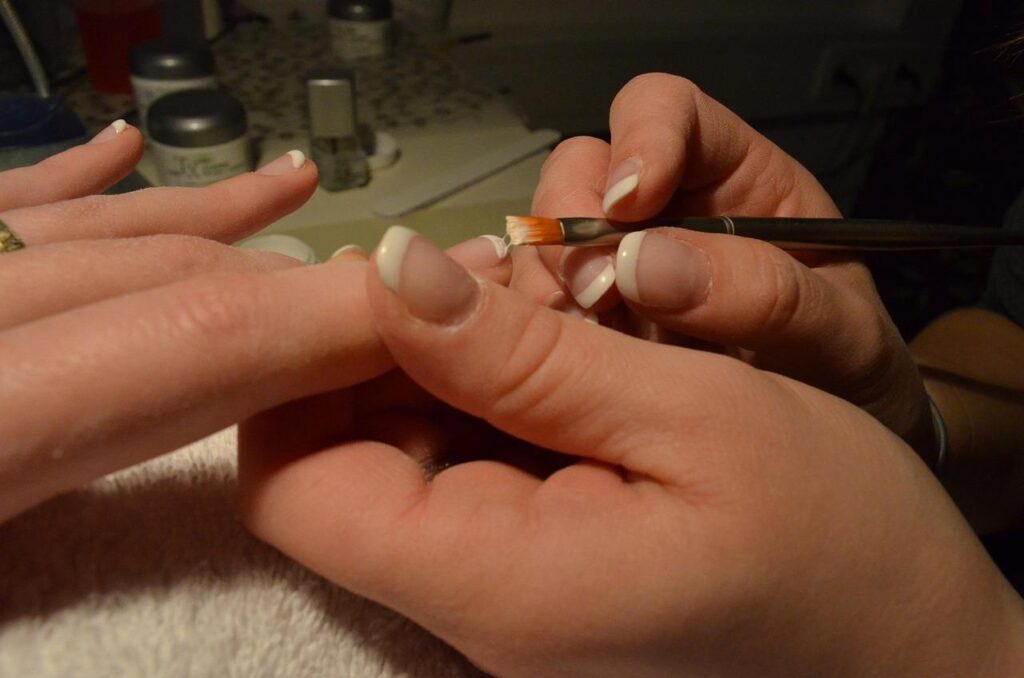 Een eigen beautybedrijf starten: vrouw voert nagelstyling uit als onderdeel van professionele beautyservices